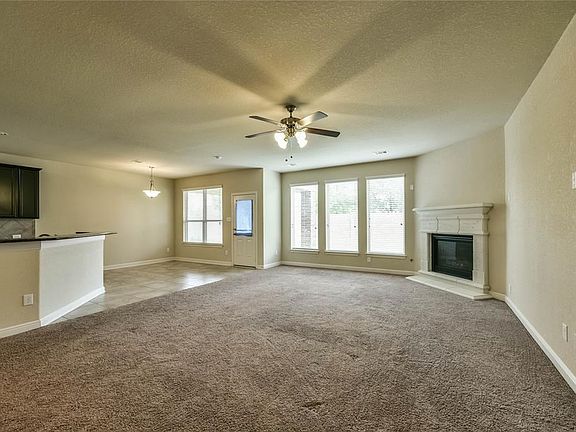 Family room surrounds fireplace and is open to the breakfast room and kitchen.