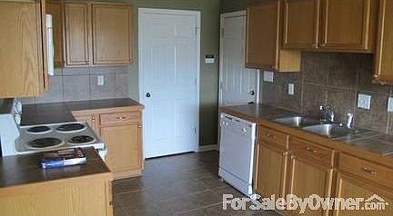 Kitchen
						:
						With tile countertops and backsplash, doors to garage and utility room