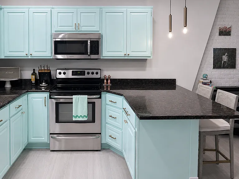 Spacious kitchen with stainless-steel appliances, ample cabinetry and counter space, pendant lighting, and a large peninsula perfect for dining or working from home.