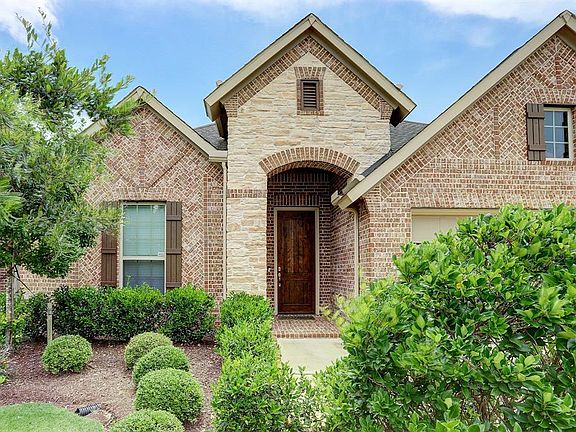 Very pretty brick detailed masonry and stonework on the front of the home along with architectural arches. There is even a brick floored entry.
