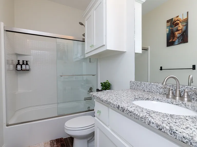 Bathroom 1 features a tub/shower combo, granite countertop with sink, and a sleek mirror_offering both comfort and style.