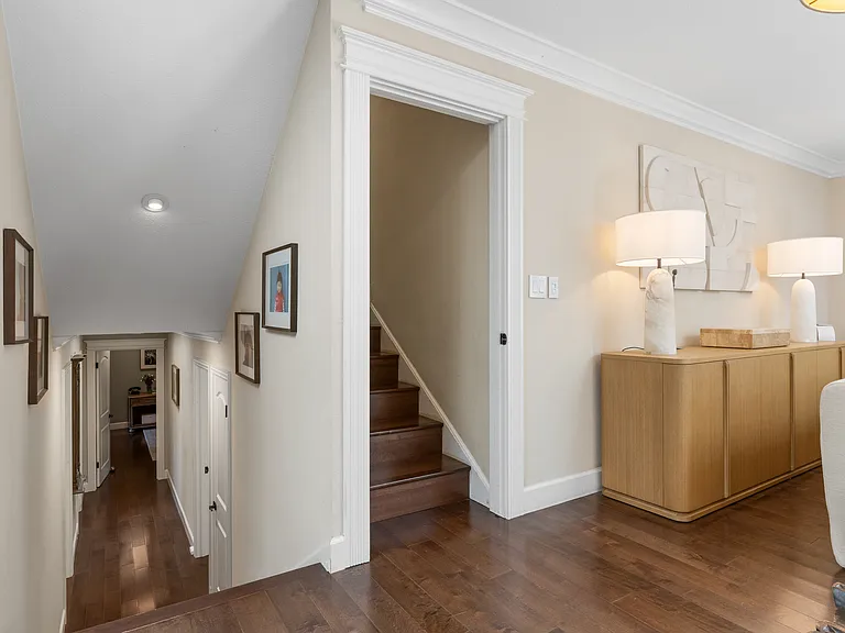 Downstairs leads to two guest bedrooms and primary suite
