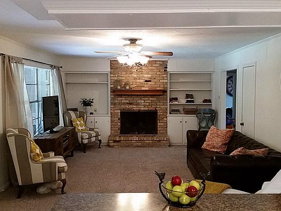 Spacious family room with brick fireplace and built in storage.