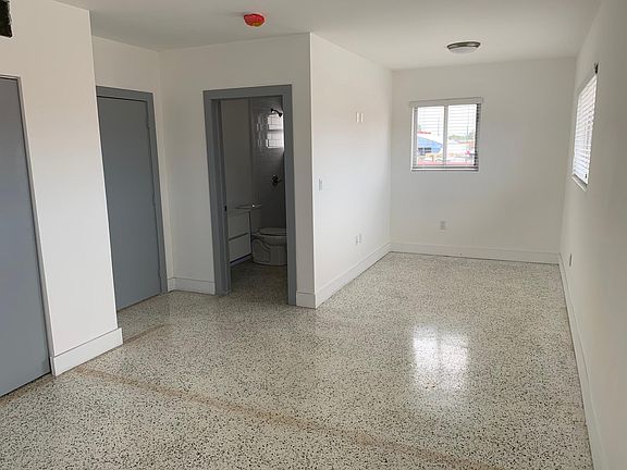 Living/Dining Room Area with View of Full Bathroom and Bedroom Entrances