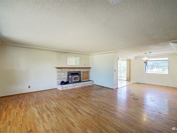 Roomy living space with hardwood floors ready to be refinished>