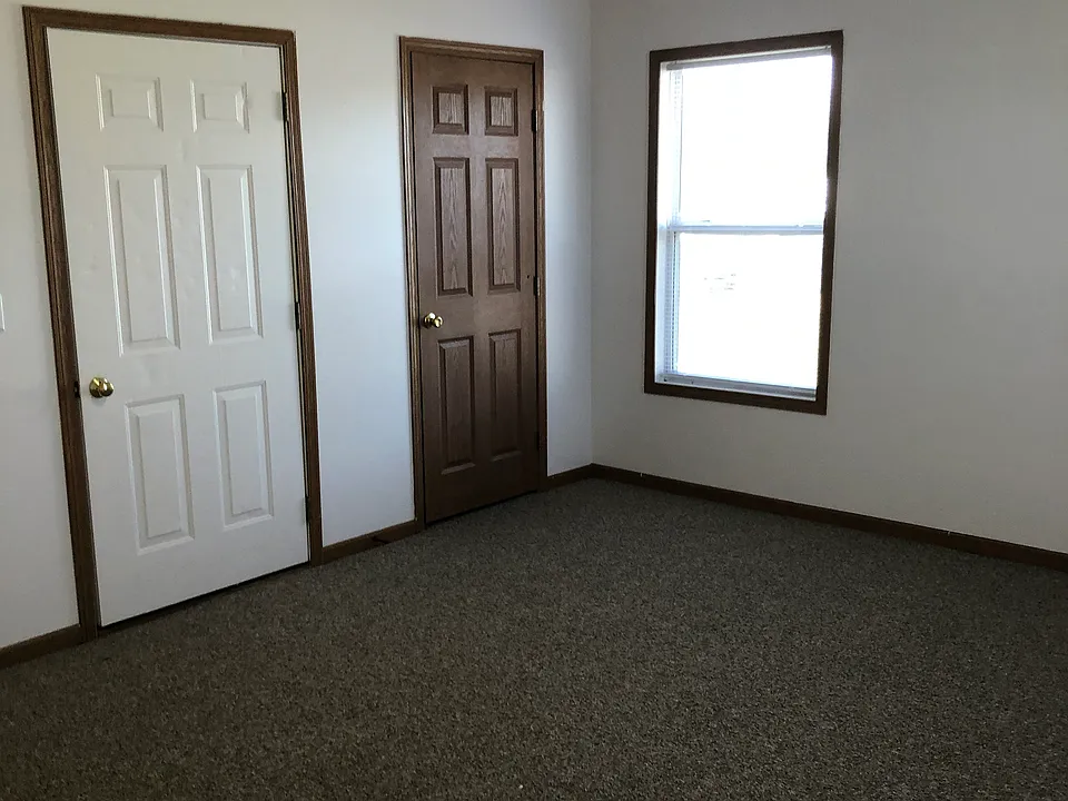 Living room with storage closet, new carpeting, and front entrance convenient to the 2 available parking spaces.
