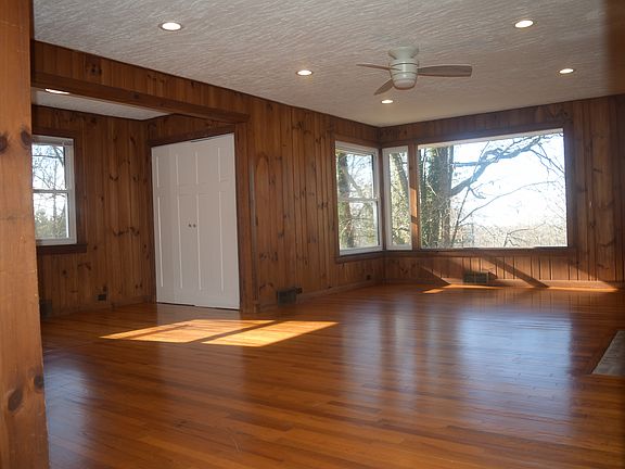 Large upstairs living room with refinished hardwood floors, original wood side paneling, large windows with seasonal mountain views, a fireplace, pantry and dining area.