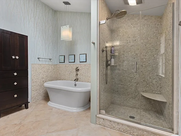 Master bath soaking tub with rainfall glass shower.