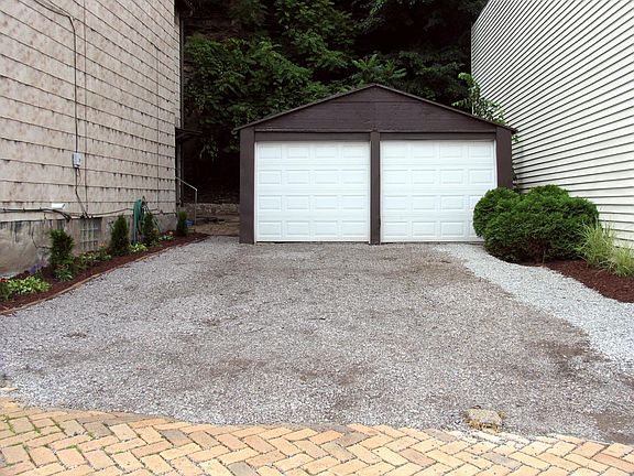 Off-street parking on the gravel parking pad. Garage is too small and only used for storage.