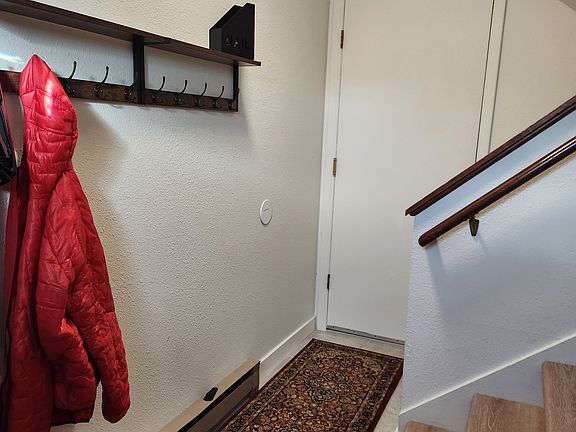 Hallway after main entry for coats and shoes. Door is shared laundry.