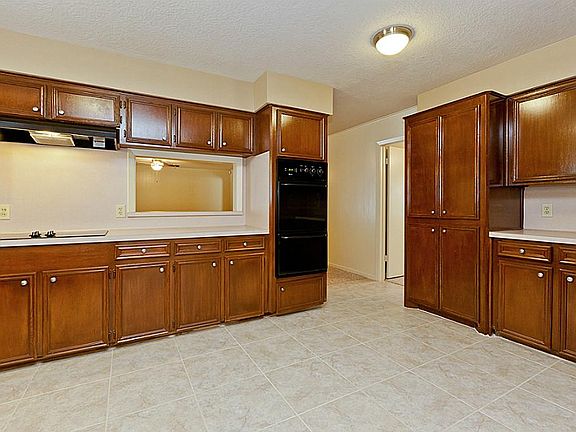 FULLY UPDATED SPACIOUS KITCHEN WITH DOUBLE OVENS, COOKTOP & RANGE HOOD + TILE FLOORING ~ LOOK AT THE REFINISHED EXTENSIVE CABINETRY ~