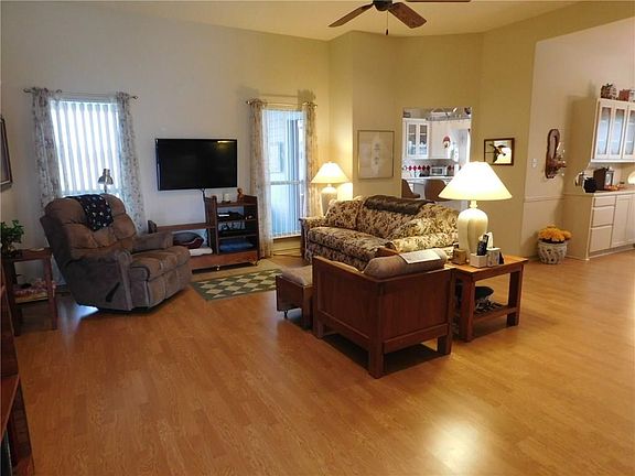FROM THE ENTRY WAY YOU WILL SEE THE SPACIOUS LIVING AREA WITH DINING AREA TO THE RIGHT AND KITCHEN IN THE BACKGROUND.