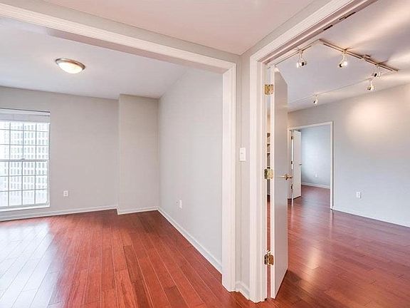 Hallway of the primary bedroom suite, with view of master bedroom and living room