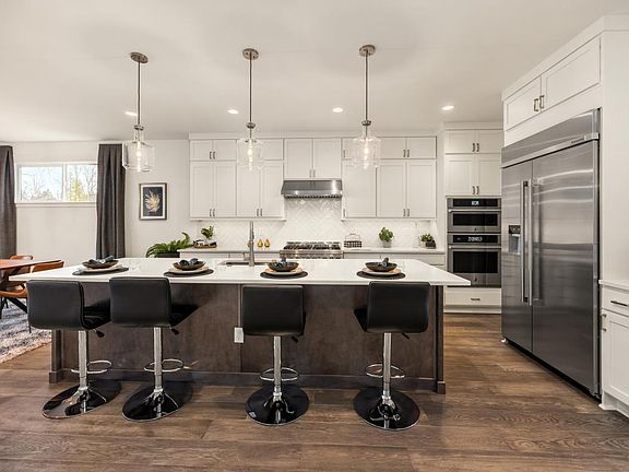 Well-designed kitchen with white shaker double-stacked cabinets