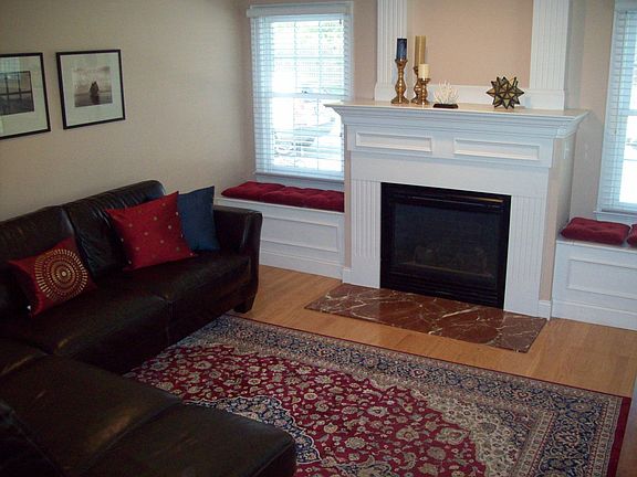 Living room with window seats and large mantled fireplace