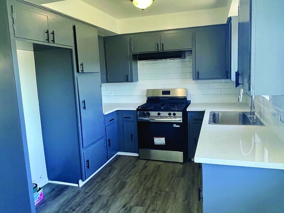 Remodeled kitchen with new quartz, tile, paint, stove, and sink. Large Stainless Sink with new Hardwood floor laminate.