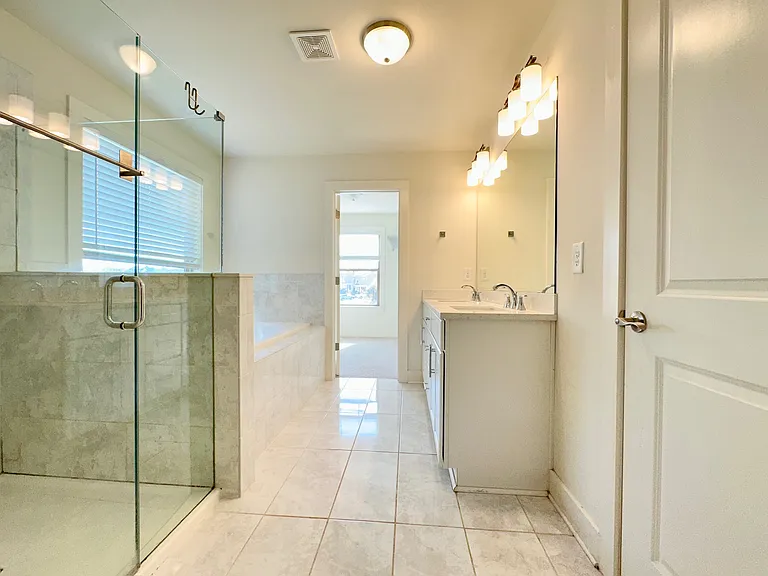 Beautifully well-lit master bathroom and spacious walk-in closet. Separate tub and shower, upgraded shower heads.
Double sinks vanity