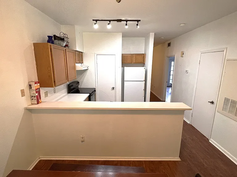 The in-unit washer and dryer are located in side the door next to the kitchen.
