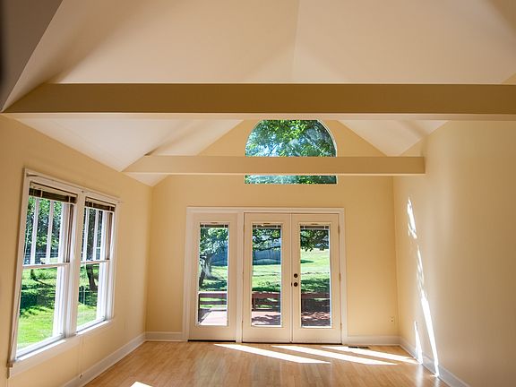 Living room with vaulted ceilings that leads to back deck.