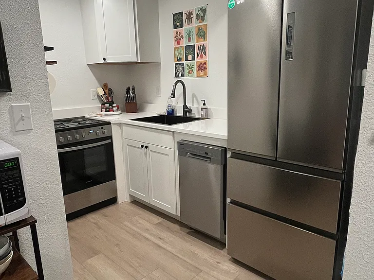 New stainless steel appliances in kitchen - fridge/freezer, dishwasher, range.