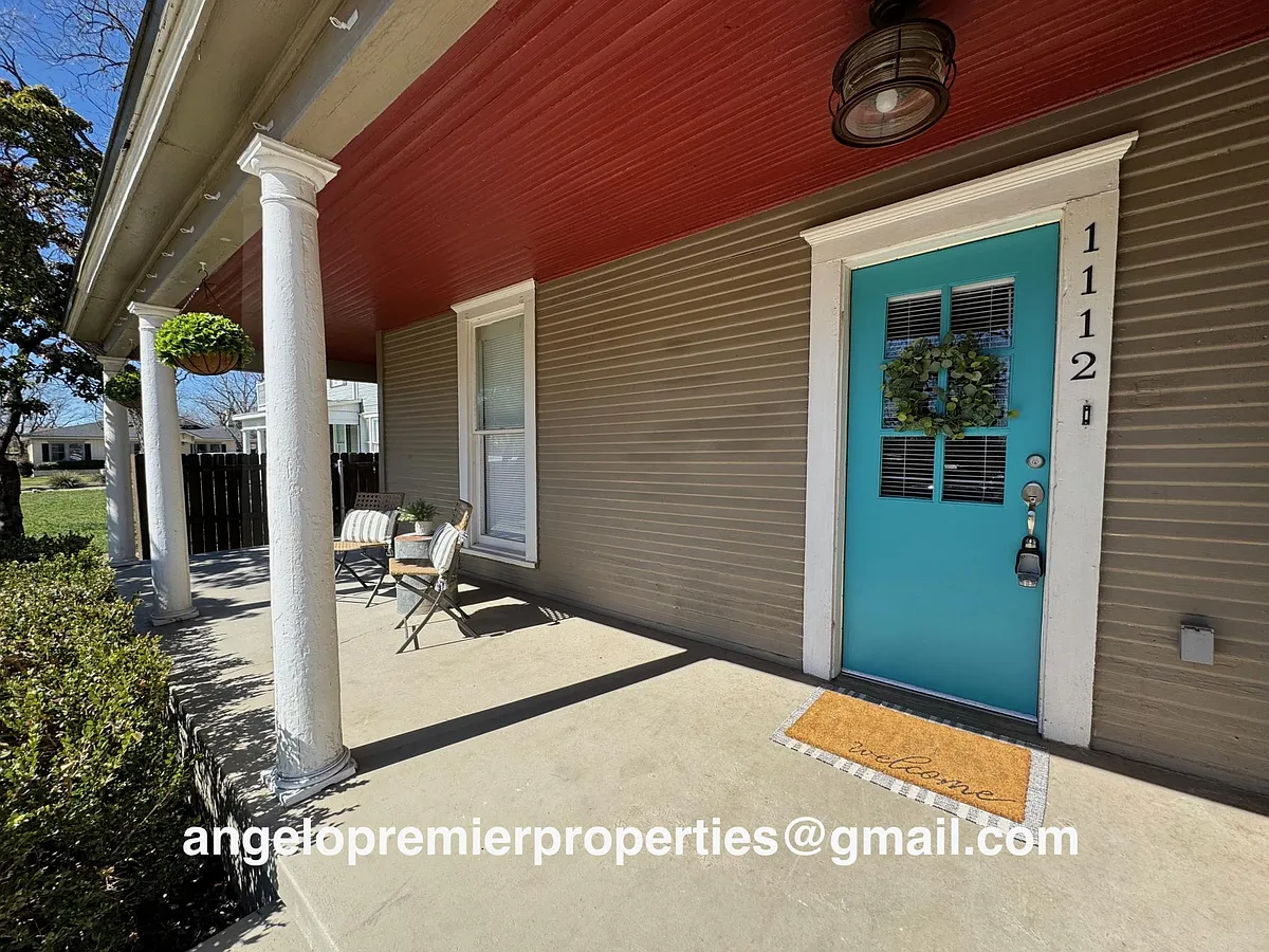 This front porch wraps around the side of the house for lots of rocking chair space! - 1112 W Harris Ave