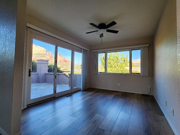 Dining room has plank flooring, sweeping red rock views and French door access to tiled back patio