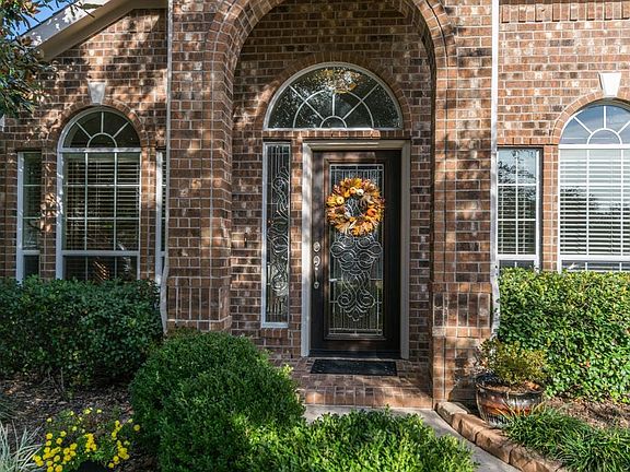 Welcoming front entry with lush landscaping.
