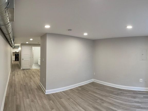 Entry looking at living room space, bathroom, and kitchen beyond.