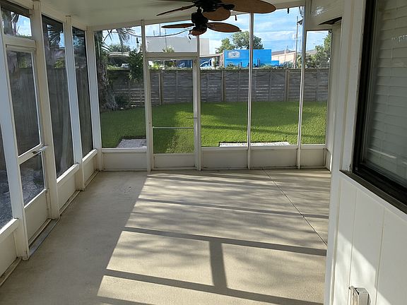Enjoy the Florida weather year-round on the screened-in patio overlooking a fully fenced, freshly landscaped backyard (2023). The paved area offers plenty of space for a grill, fire pit, or outdoor dining setup, while the grass area is ideal for pets