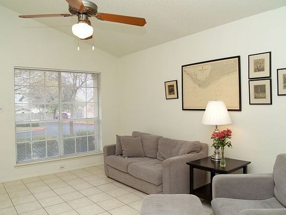 Living room with tiled floors and vaulted ceiling.