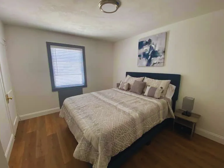 Bright bedroom with a queen bed, premium linens and cozy bedside lamps.