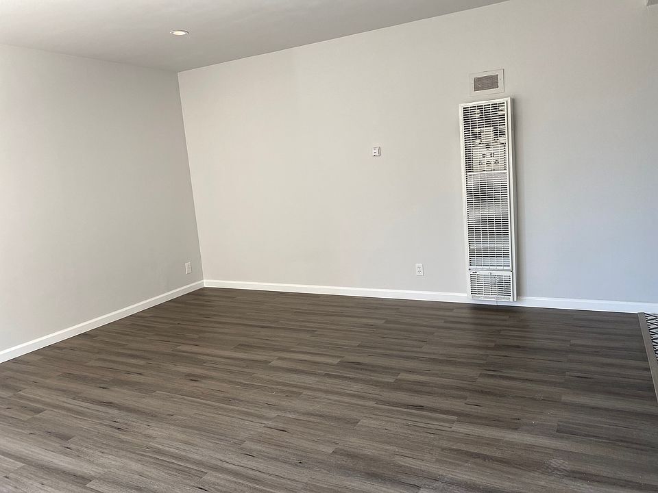 Living room with recessed lighting, custom paint colors, and custom plank flooring