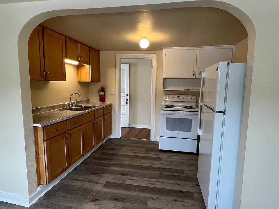Kitchen with new stove, refrigerator and flooring