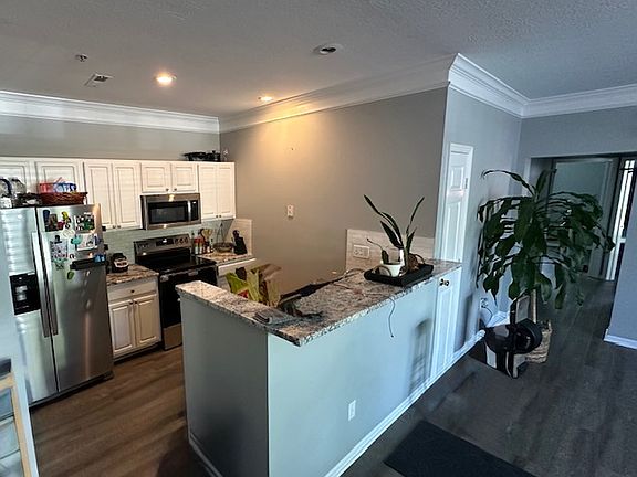 Kitchen open to living room with breakfast bar.