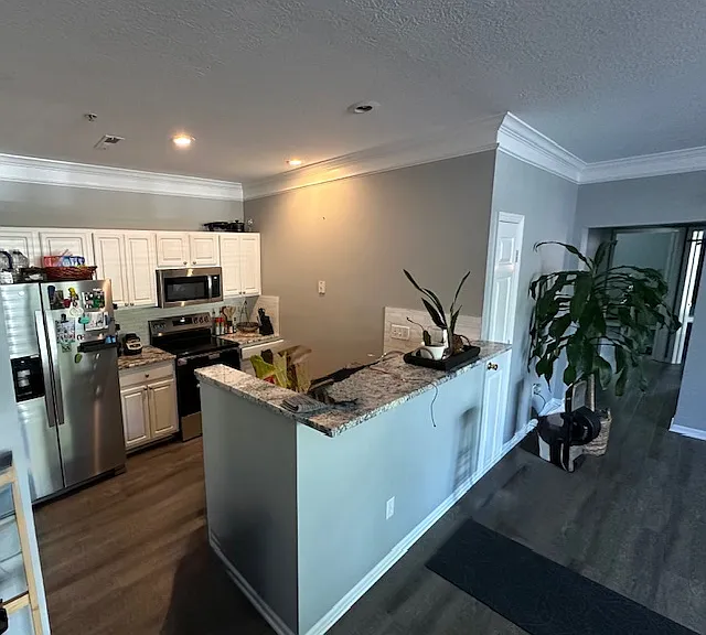 Kitchen open to living room with breakfast bar.