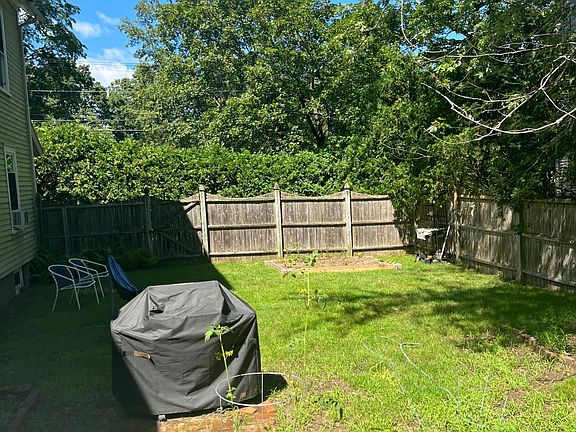 Fenced-in back yard with grill.