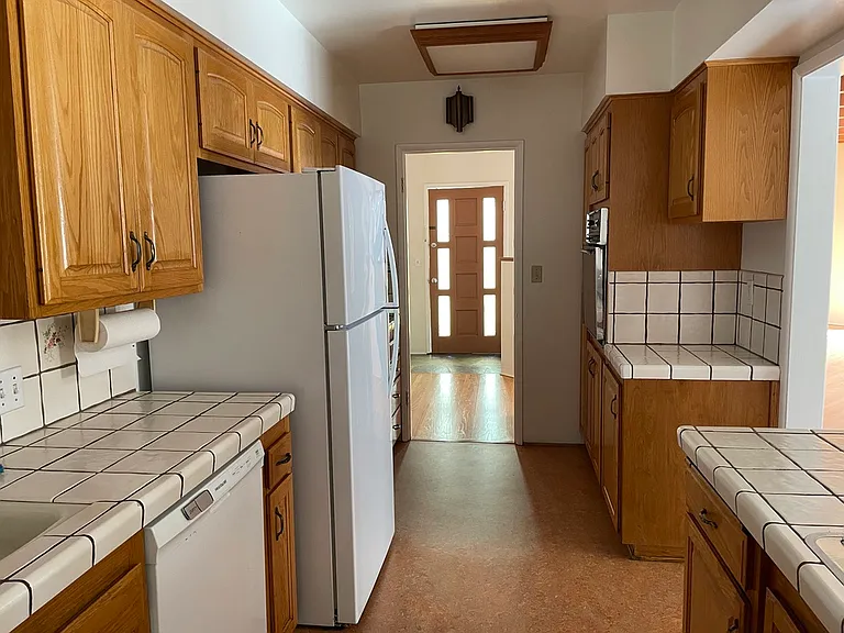 Kitchen view toward front entry, to the right is access to dining area