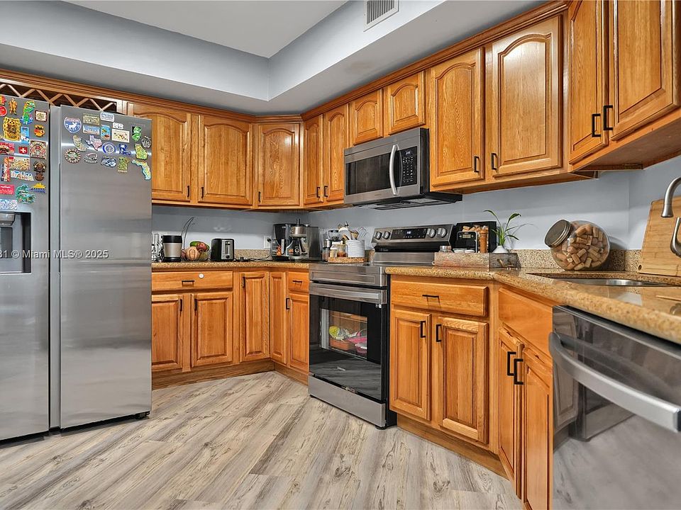 A Kitchen With Refrigerator Cabinets And Wooden Floor North Miami: Stylish & Functional Designs