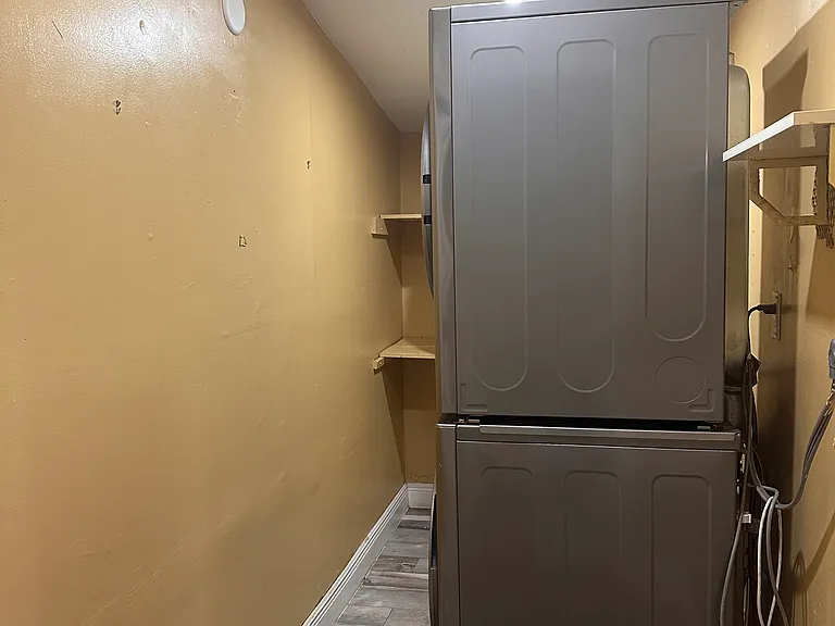 Spacious laundry room with energy-efficient stainless steel washer and dryer for convenience.