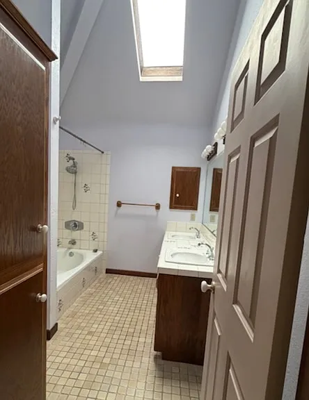 Master bathroom with great soaker tub, two sink vanity, cathedral ceiling and skylight.