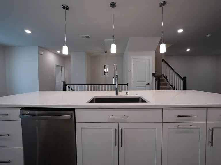 Kitchen features stainless steel appliances, gas range, large island, quartz countertops, under-cabinet lighting and outlets, lots of cabinetry and overhead lighting. Lights are smart/WiFi-enabled.