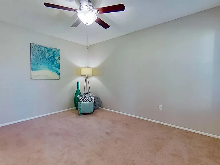 Discover the comfort of this bedroom in The Newport Autograph floor plan featuring cozy carpeting, ample natural light, and a ceiling fan for year-round comfort.
