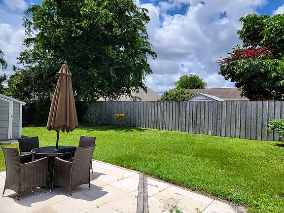 Back yard with fence and small patio. Patio table and chairs included in rental.