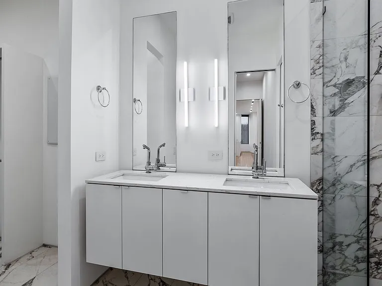 Dual floating vanity with white cabinetry and integrated sinks