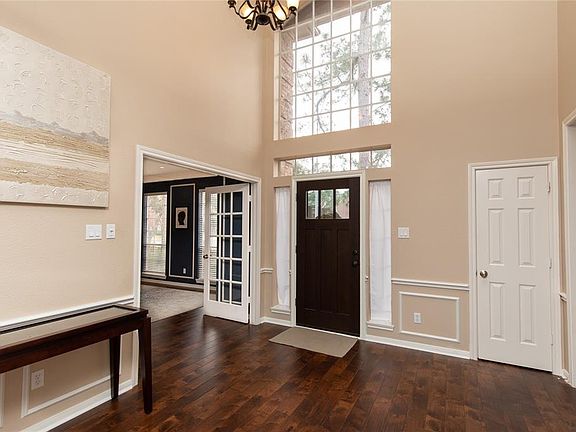 Inside you find this spacious entry with a soaring ceiling, stunning floors, beautiful lighting and a convenient coat closet.
