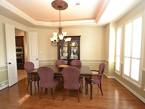 Dining room enhanced by hardwood floors, raised ceilings, double crown molding with accent lighting,