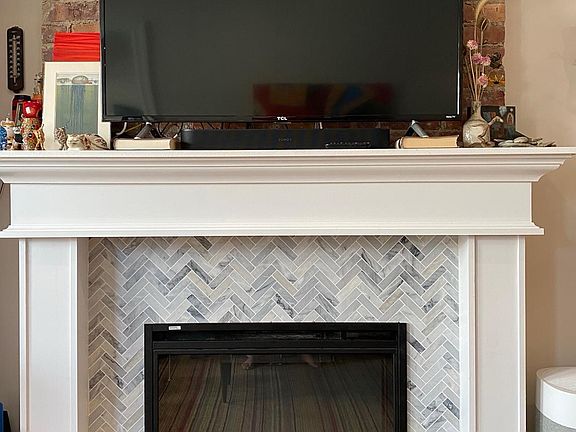 Exposed brick in the living room with a gas fireplace. So cozy!