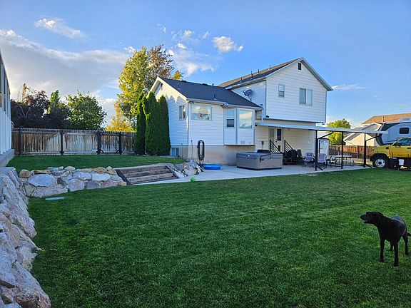 Larg backyard with awning and hottub.