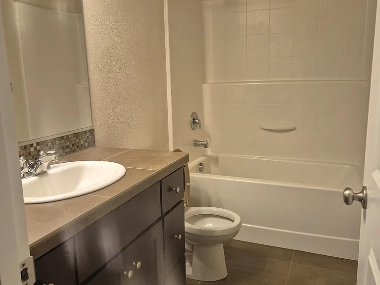 Guest bathroom includes shower, tub and lots of cabinets for storage.