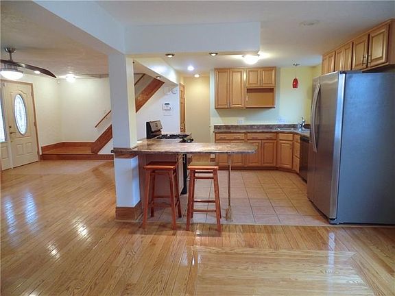 Another view of the Open-Concept main floor, the Kitchen offers newer ceramic tile floor and breakfast bar.
